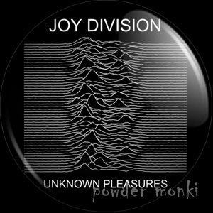 Powder Monki’s round black badge and magnet preview with the Unknown Pleasures chart and small band and album captions