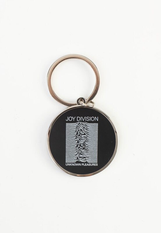 Round black metal keychain with a small rectangular Unknown Pleasures chart beneath JOY DIVISION